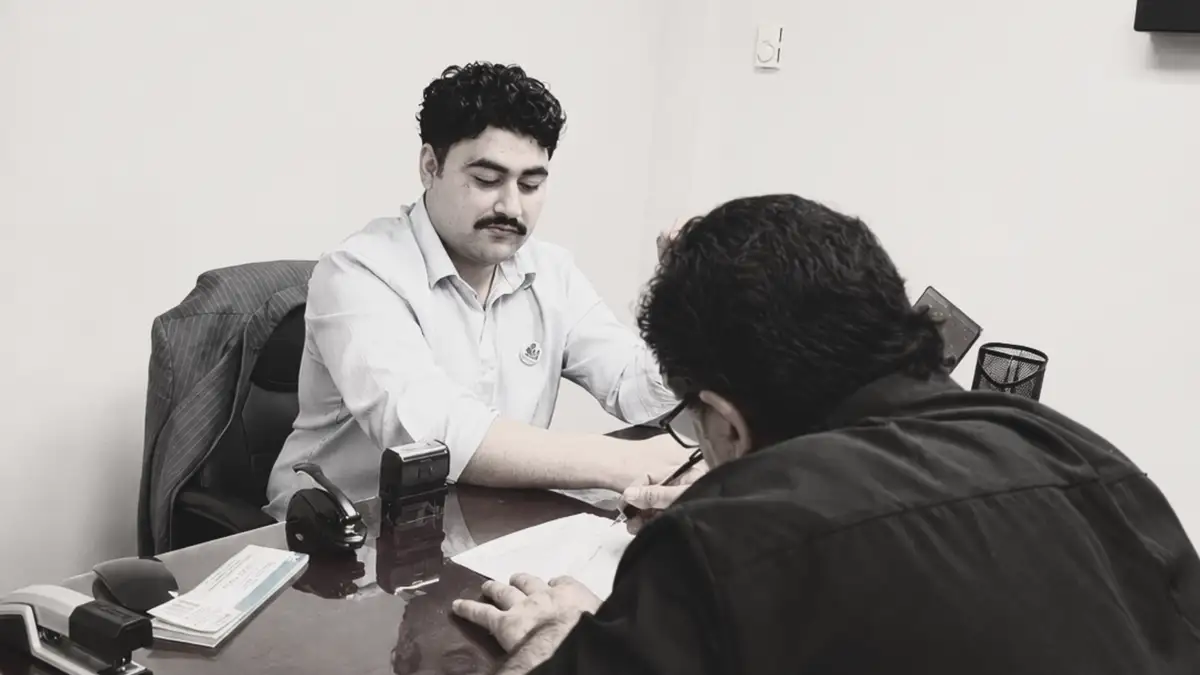 A notary public assisting a person with a document signing.